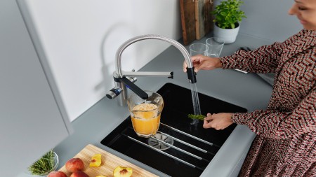 A Woman cleans herbs with a BLANCO Evol-S Pro Soda & Filter Tap